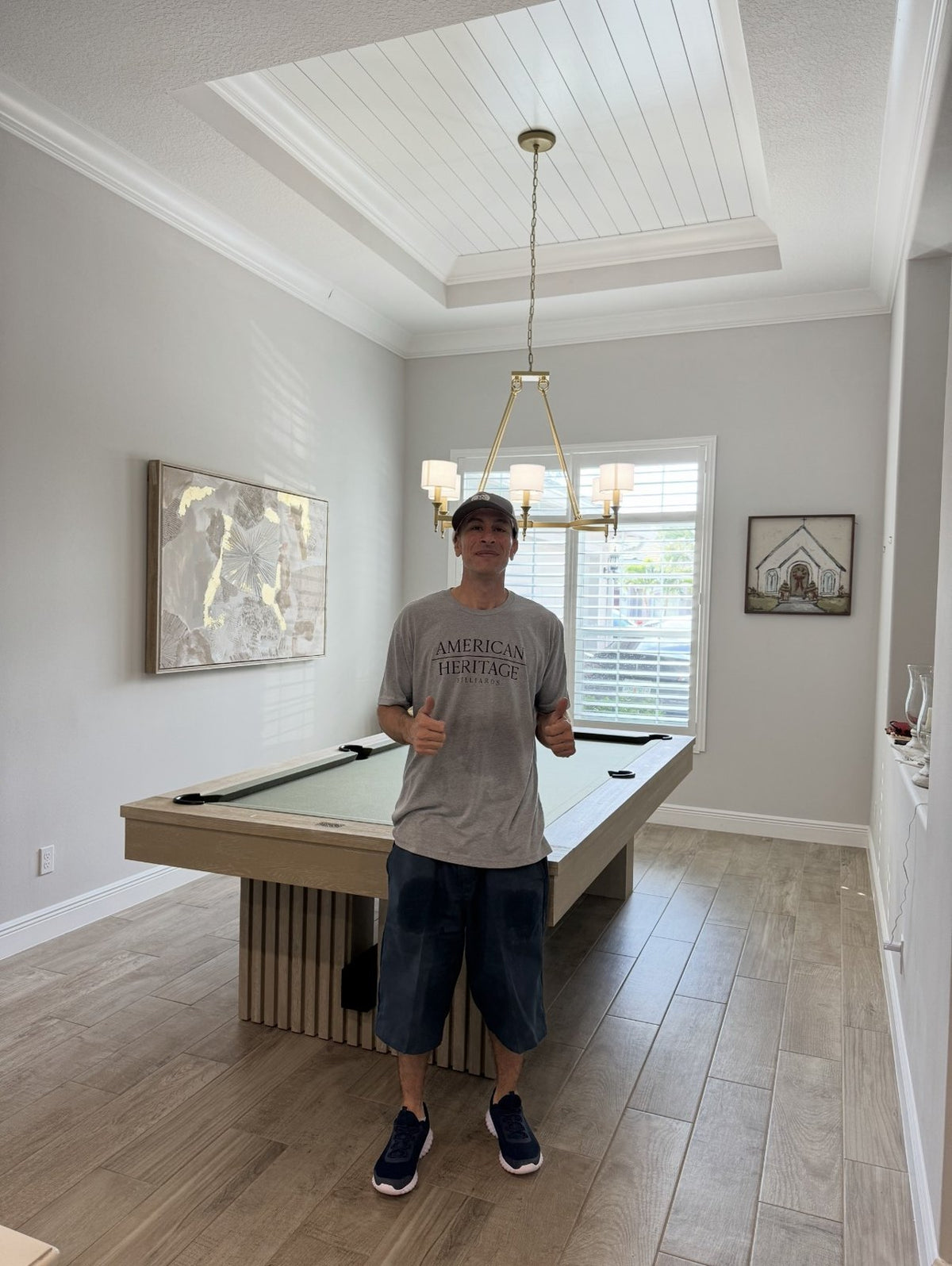 Pool Table MD installer giving a thumbs-up beside a freshly installed pool table in a Florida home
