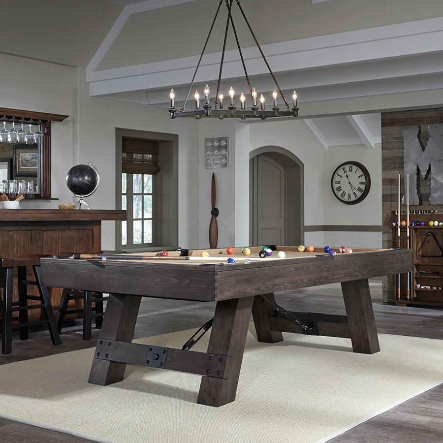 Savannah Pool Table in Charcoal in a rustic game room under an iron chandelier